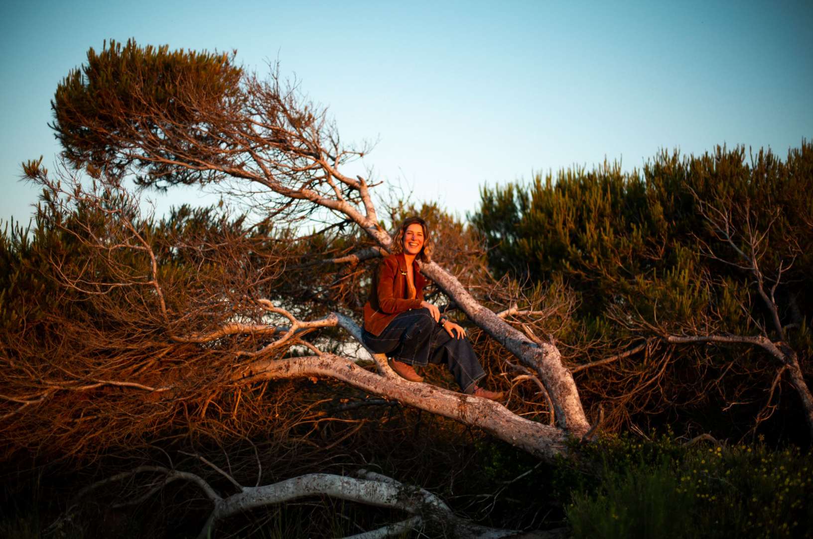 Esther Martínez, Psicóloga Sanitaria, sentada en un pino al atardecer en el Entorno Natural de Sagunto