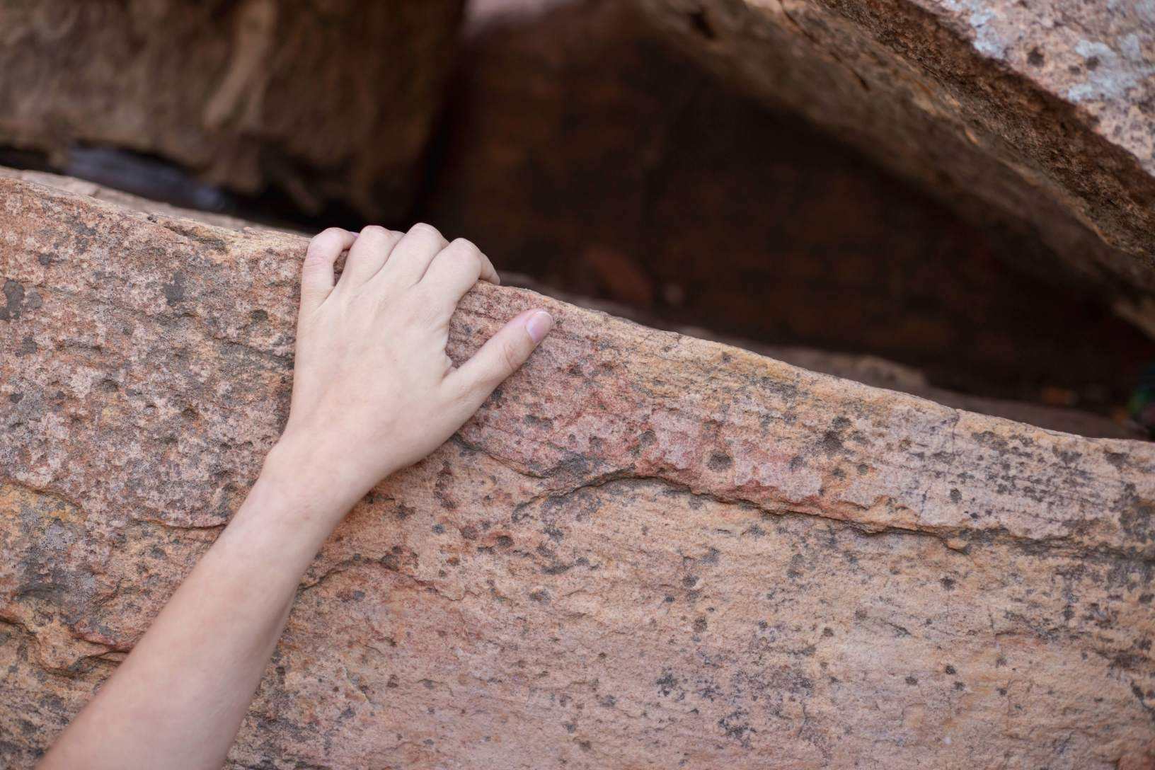 Mano apoyada en una roca en plena naturaleza