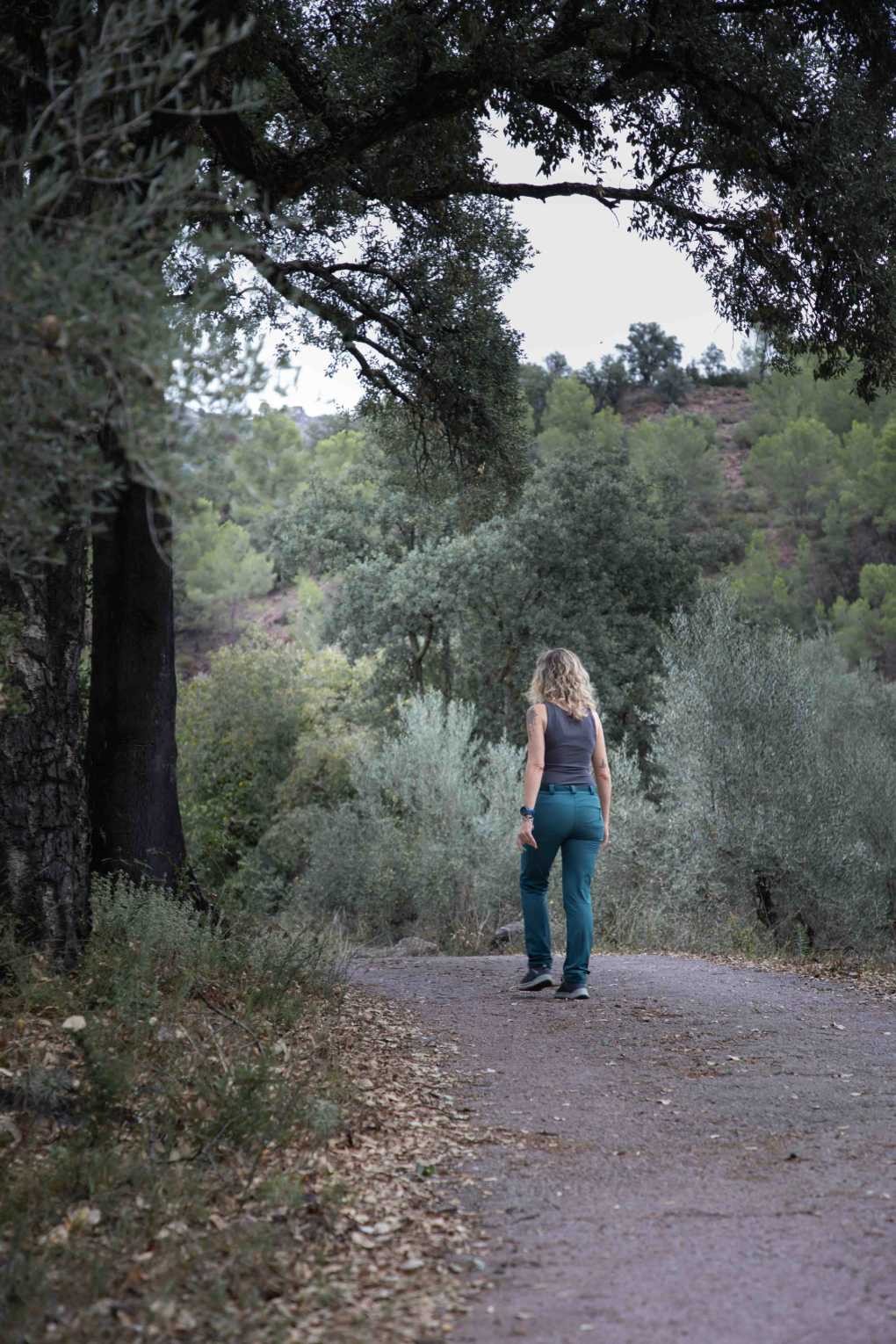 Esther Martínez caminando por un camino entre árboles